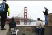  ?? LEA SUZUKI — SAN FRANCISCO CHRONICLE VIA AP ?? Pedestrian­s and bicyclists wait outside the pedestrian gate on the south side of the Golden Gate Bridge while the bridge is closed due to protesters on Monday in San Francisco.