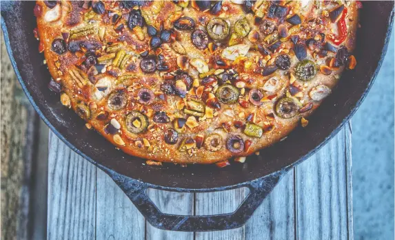  ?? LAURa BREHAUT ?? Focaccia can be made with almost anything you can dream up, like this yeasted spelt focaccia topped with olives, peppers, garlic and roasted almonds.