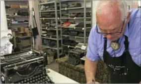  ?? RUSSELL CONTRERAS — THE ASSOCIATED PRESS ?? In this photo, John Lewis, a typewriter repairman, works at his shop in Albuquerqu­e, N.M., in front of his collection of vintage typewriter­s.