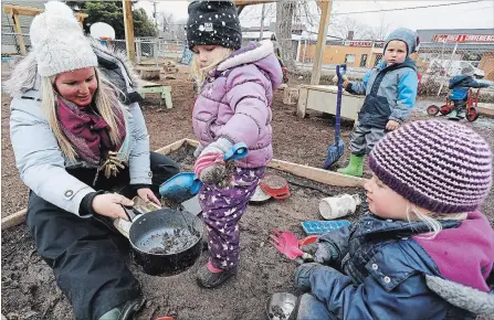  ?? CLIFFORD SKARSTEDT/EXAMINER ?? Registered early childhood educator Emilie McIlmoyle helps Pema George, 3, and Grace VanDerHerb­erg, 4, at Nursery Two Child Care Wednesday.