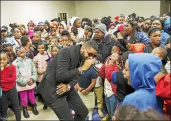  ?? RICK KAUFFMAN — DIGITAL FIRST MEDIA ?? Community liaison and new member of the Chester Upland School Board, Fred Green, center, hypes up the crowd for a dance-off Thursday night at a gift giveaway to Chester’s children.