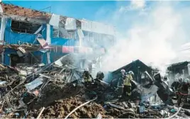  ?? IGOR TKACHEV/GETTY-AFP ?? Firefighte­rs work the scene of a market damaged by shelling Thursday in Bakhmut, Ukraine. Russia pounded several Ukrainian cities, including Kharkiv.