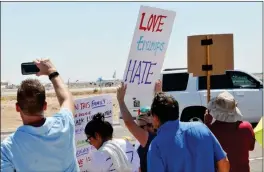  ?? Buy this photo at YumaSun.com PHOTO BY WARNER STRAUSBAUG­H/YUMA SUN ?? PROTESTERS WATCH AS Air Force One taxis at the Marine Corps Air Station Yuma off East 32nd Street in Yuma on Tuesday. Roughly 200 people lined the block between S. Avenue 2 1/2 E and 3E to protest the arrival of the President Donald Trump.