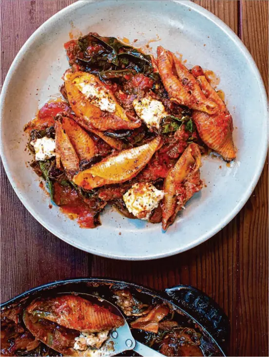  ?? Christian Reynoso/The Chronicle ?? Skip the laborious stuffing process with this recipe for big baked pasta shells with ricotta and chard and bathed with a rich tomato sauce.