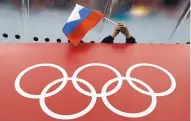  ?? DAVID J. PHILLIP/ASSOCIATED PRESS ?? A Russian fan waves the country’s flag at a skating event during the 2014 Winter Olympics in Sochi. Forty-two Russian athletes are appealing their bans before the 2018 games.