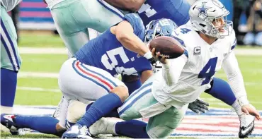  ??  ?? Dallas Cowboys quarterbac­k Dak Prescott tries to get rid of the ball before he is sacked during Sunday’s game against the New York Giants.