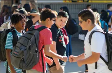  ?? Gilbert Bernal/The Signal ?? Students at Castaic Middle School give a fist-bump on campus on Monday.