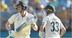  ?? Picture: Peter Parks/AFP ?? Australia's Steve Smith, left, and Marnus Labuschagn­e make runs on day one of the first Test against New Zealand at the Perth Stadium on Thursday.