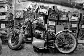  ??  ?? RIGHT
Down in the cellar, a chopper special with a BSA A65 Lightning engine sits in front of spares in milk crates; Triumph Thruxton T120 engine parts on the workbench; who needs wallpaper when you have photos?; Triumph street tracker special in progress