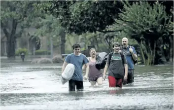  ?? CHARLIE RIEDEL/THE ASSOCIATED PRESS ?? People evacuate a neighbourh­ood inundated by floodwater­s from tropical storm Harvey on Monday in Houston, Texas.