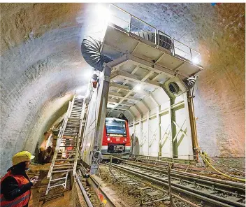  ?? FOTO: DEUTSCHE BAHN/DPA ?? Während Arbeiter von dem mobilen Portal aus die Innenschal­e der Röhre im Kuckucksla­y-Tunnel zwischen Trier-Ehrang und Kordel abtragen, rollen die Züge weiter. Der 150 Jahre alte Tunnel wird derzeit vergrößert.