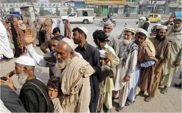  ??  ?? Cash line: Queuing for money in Pakistan under a scheme supported by UK foreign aid