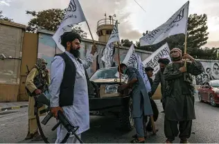  ?? Victor J. Blue / New York Times ?? Taliban fighters wave their flag outside the U.S. Embassy in Kabul. The rapid takeover of Afghanista­n derailed the CIA’s plans to refocus on gathering intelligen­ce about global rivals.