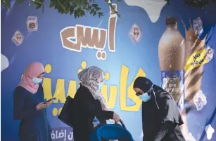  ??  ?? ARAB WOMEN wearing protective face masks wait at a bus stop in east Jerusalem yesterday. ( Yonatan Sindel/ Flash90)