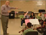  ?? SUBMITTED PHOTO ?? Audubon Symphony Orchestra conductor John Mayer rehearses with young violinists from Phoenixvil­le’s Crescendo violin program for a Dec. 8concert in Trappe.
