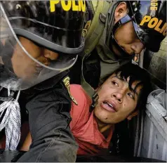  ?? MARTIN MEJIA/ASSOCIATED PRESS ?? An anti-government protester who traveled to the capital to march against Peruvian President Dina Boluarte is put in a police vehicle Thursday during clashes in Lima, Peru.