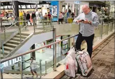  ?? DANA JENSEN/THE DAY ?? Shoppers have flocked over the years to the Crystal Mall on Thanksgivi­ng and Black Friday. Here, Andrew Roberts stands with a collection of shopping bags while waiting outside a store for his wife and daughter during a shopping spree Nov. 24, 2016.