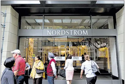  ?? AP/TED S. WARREN ?? People stand outside a Nordstrom’s flagship department store in downtown Seattle in September. Survey results released Thursday said Americans will increase spending by 6 percent in November and December.