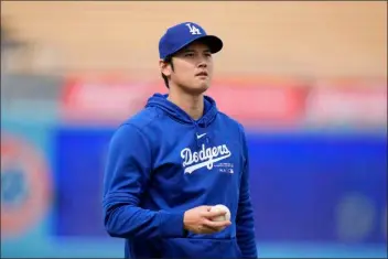  ?? JAE C. HONG — THE ASSOCIATED PRESS ?? Los Angeles Dodgers’ Shohei Ohtani stands on the field during warmups before the team’s spring training baseball game against the Los Angeles Angels Monday, March 25, 2024, in Los Angeles.