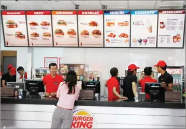  ?? HONG MENEA ?? A customer places an order at Burger King in Phnom Penh’s Boeung Keng Kang district in 2014.