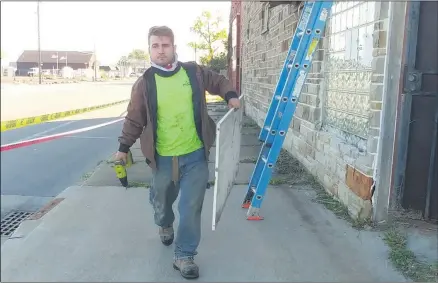  ?? ZACHARY SRNIS — THE MORNING JOURNAL ?? Josh Knight, a demolisher with ProSupply, removes a Cantina Sports Bar sign as the building, that also was formerly Tony J’s bar, was demolished Oct. 12in South Lorain.