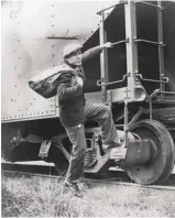  ?? ALAN FISHER / LIBRARY OF CONGRESS ?? Lou Ambers, sac de voyage à l’épaule, s’accrochant à l’échelle d’un train en 1935