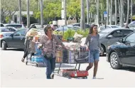  ??  ?? Residents gather water and necessitie­s in preparatio­n for the arrival of Hurricane Irma in North Miami.