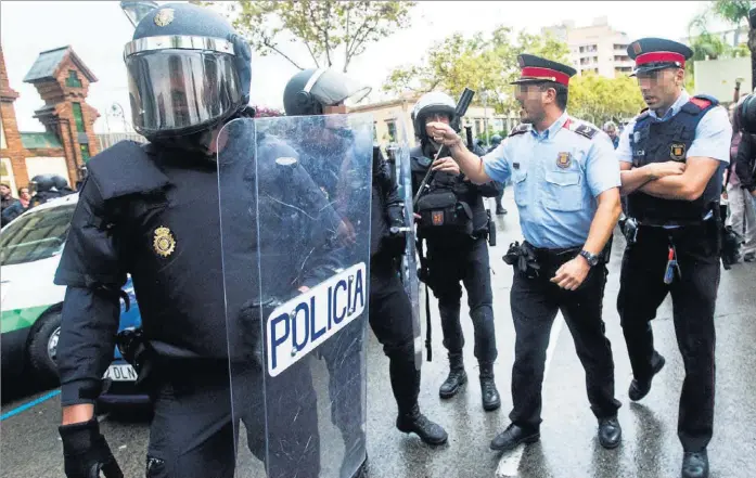  ?? EFE ?? Un ‘mosso d’esquadra’ se encara con agentes de la Policía Nacional durante el referéndum del 1 de octubre, en L´Hospitalet de Llobregat (Barcelona) .