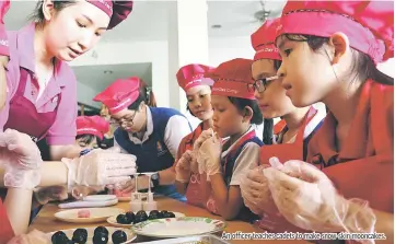  ??  ?? An officer teaches cadets to make snow-skin mooncakes.