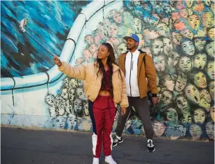  ?? (Alan Behr/TNS) ?? A COUPLE snaps a selfie in front of the mural on the Berlin Wall East Side Gallery.