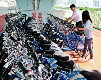 ??  ?? Los trabajador­es acomodan las bicicletas en una de las zonas de estacionam­iento del ciclocarri­l.