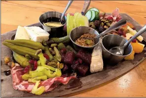  ?? Arkansas Democrat-Gazette/ERIC E. HARRISON ?? The assortment of cured meats, cheeses, fruits, nuts and vegetables on Raduno’s Antipasto Board changes regularly.