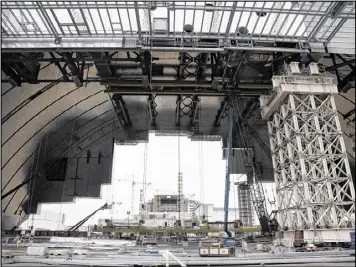  ?? FREM LUKATSKY PHOTOS / ASSOCIATED PRESS ?? Workers build an arch-shaped confinemen­t that will be moved on rails over the sarcophagu­s and reactor building damaged by an explosion at the Chernobyl nuclear power plant in Chernobyl, Ukraine.