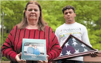  ?? MARY ALTAFFER THE ASSOCIATED PRESS ?? Florence Hopp, left, holds a photograph of herself and her husband Robert Hopp at their home in Boonton, N.J., as her son J.J. Brania-Hopp holds the flag presented to them after his father’s death.