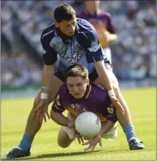  ??  ?? Páraic Curtis under heavy pressure from Alan Brogan.