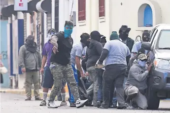  ??  ?? Paramilita­res rodean la basílica de San Sebastián, en Diriamba, Nicaragua. Grupos armados de partidario­s del presidente Ortega irrumpiero­n en el templo, que permanecía sitiado, y agredieron a los obispos.