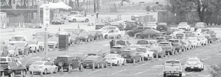  ?? MIKE STOCKER/SOUTH FLORIDA SUN SENTINEL ?? Cars line up Nov. 5 as people wait at the Hard Rock Stadium COVID-19 testing site in Miami Gardens.