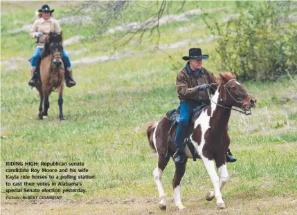  ?? Picture: ALBERT CESARE/AP ?? RIDING HIGH: Republican senate candidate Roy Moore and his wife Kayla ride horses to a polling station to cast their votes in Alabama's special Senate election yesterday.