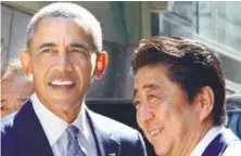  ??  ?? Obama is greeted by Abe in front of a sushi restaurant in Tokyo’s Ginza shopping district yesterday.