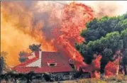  ?? AFP ?? ▪ A house is engulfed by a huge blaze during a wildfire in Kineta, near Athens, on Monday.