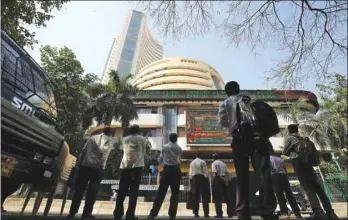  ??  ?? People look at a screen displaying the share prices on the facade of the Mumbai Stock Exchange building. The Sensex closed down 190.29 points to 35,150.01 yesterday.