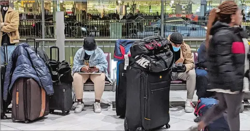  ?? LEE HOWARD/THE DAY ?? Masks were omnipresen­t Thursday, March 12, 2020, at the Charles de Gaulle Airport in Paris as airline passengers waited for flights back to the United States.