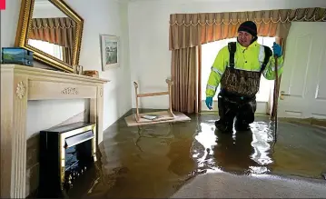  ??  ?? Chaos: Steve Lamb examines the damage to his father’s home in nearby East Cowick