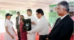  ??  ?? One of the environmen­tal pioneers receives a prize from Hon. Anuradha Jayarathna, the Deputy Minister of Mahaweli Developmen­t and Environmen­t. Officials of Swadeshi Indurstial Works PLC looks on.