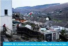  ?? ?? RHONDDA, UK: A delivery driver carries a box down a flight of steps in Tylorstown near the Tylorstown tip on December 6, 2023 in the Rhondda Valley, south Wales.