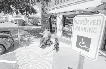  ?? Melissa Phillip / Houston Chronicle ?? James Van Winkle, 60, with his service dog, Roku, discusses the new disabled parking spaces, ramp and turnaround space recently installed at a Conroe shopping center as part of a settlement. In the past two years, he has filed 45 ADA lawsuits. He says...