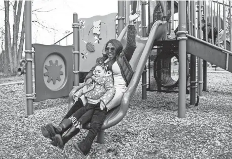  ?? PHOTOS BY JUNFU HAN/DETROIT FREE PRESS ?? Tiffany Johnson and her daughter Trust Johnson, 4, both of Detroit take the slide together at the playground of Bauervic Woods Park in Southfield on Thursday.