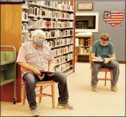  ?? (NWA Democrat-Gazette/Lynn Kutter) ?? Lynn Kutter may be reached by email at lkutter@nwadg.com. Prairie Grove City Council members Rick Clayton and Doug Stumbaugh attend a meeting last week held in the middle of Prairie Grove Public Library. Those at the meeting were spaced about 6 feet apart, based on safe distancing guidelines issued by Gov. Asa Hutchinson.