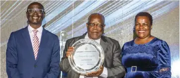  ?? ?? Mr Clement Ruzengwe (centre), the First Black CA to be admitted (1979) receiving his award from Mrs. Manyara Chigunduru of ICAZ and Mr. Roy Chimanikir­e of Econet