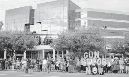  ?? PATRICK SEMANSKY/AP ?? People gather for a 2019 vigil for gun violence victims near the NRA in Fairfax, Va. Despite troubles, its pro-gun message is still popular.